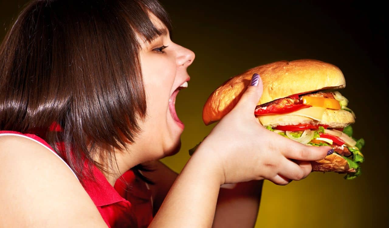 Overweight Woman Eating Hamburger