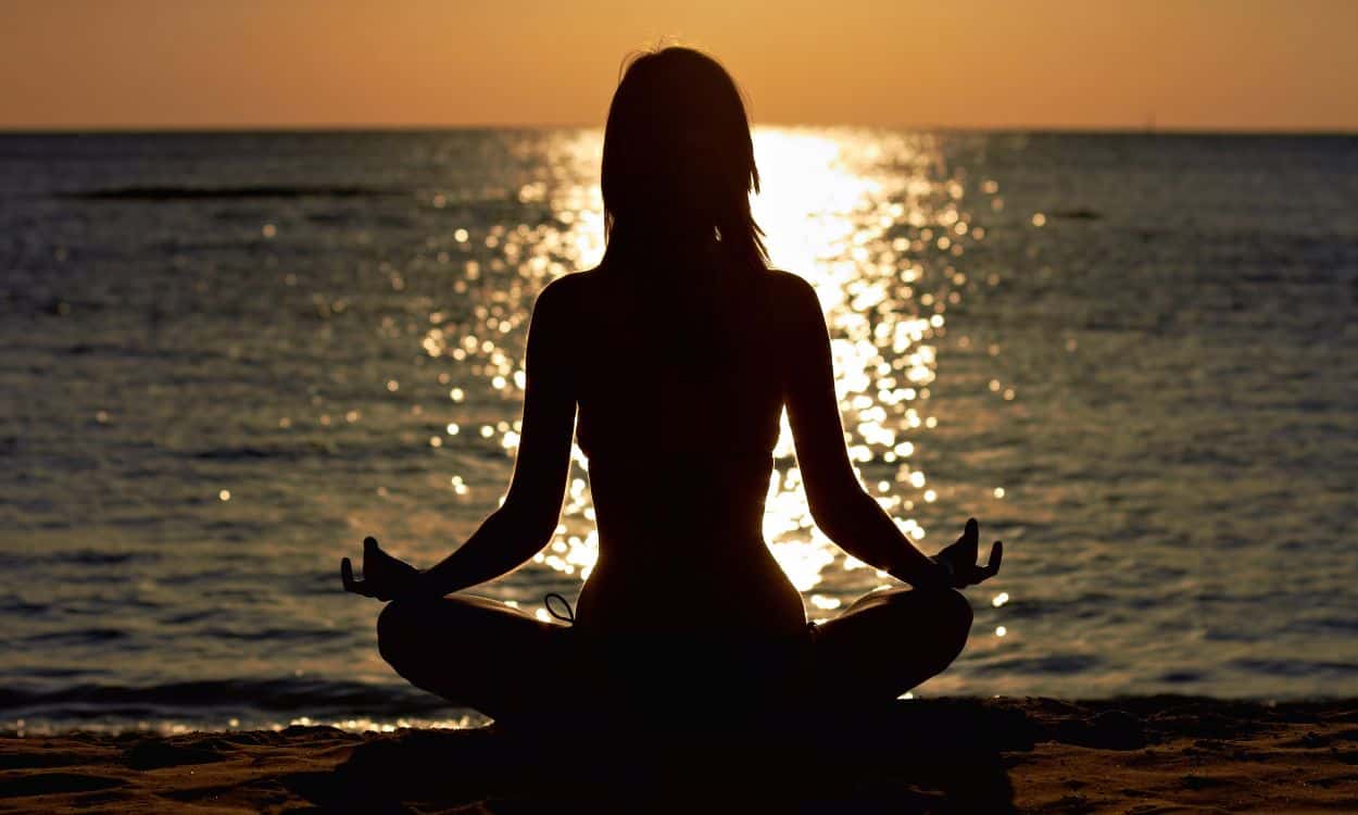 Woman Mediates on the Beach