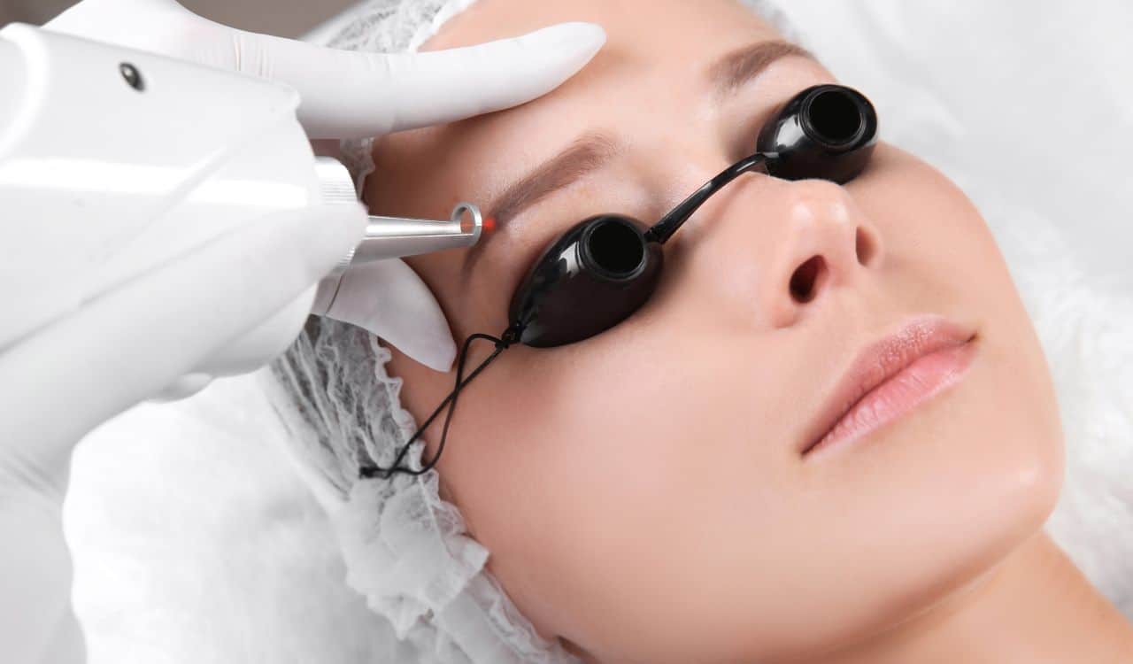 Young Woman Undergoing Laser Removal Of Eyebrow